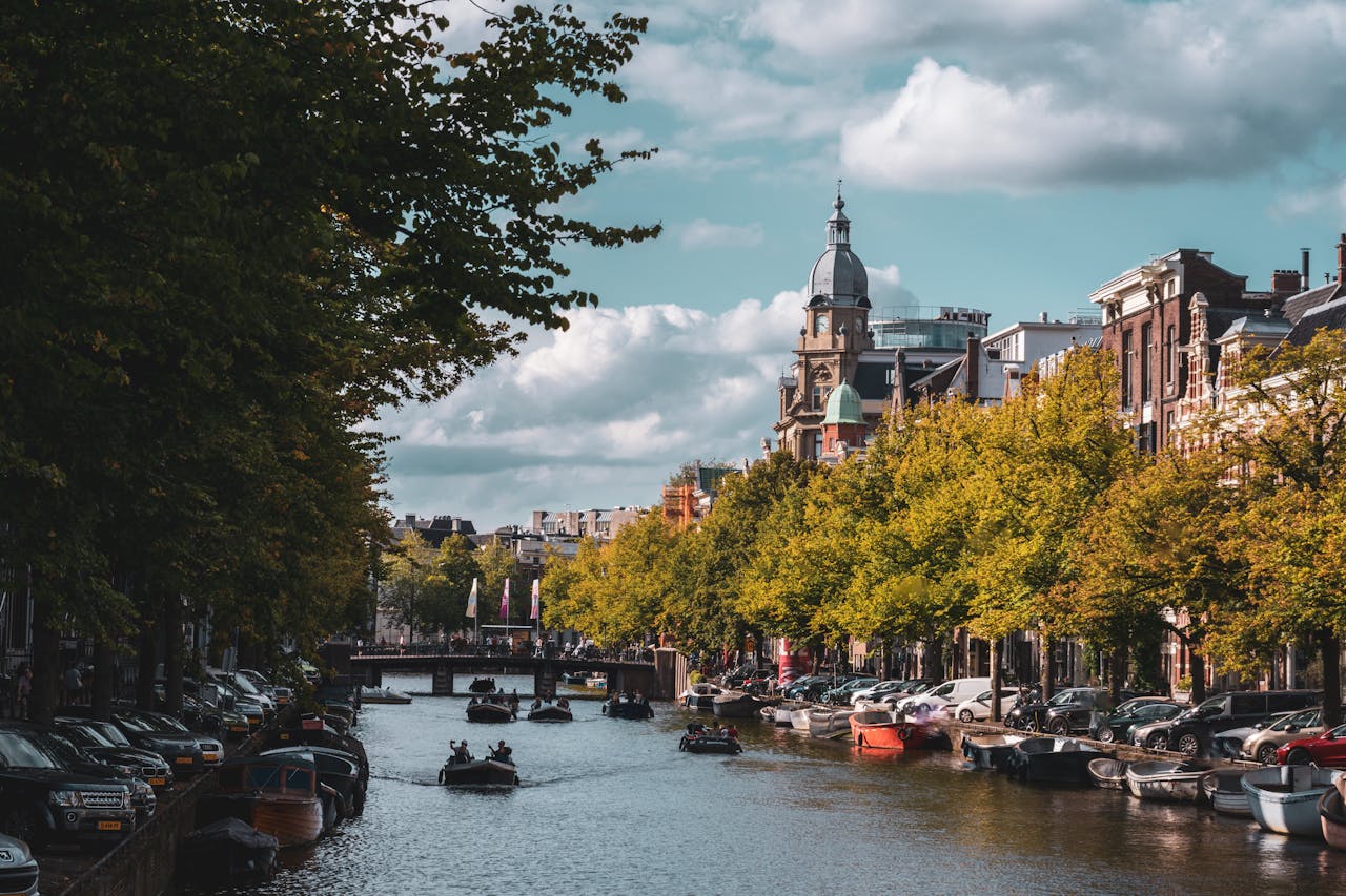 services-04 Experience the charming canals of Amsterdam adorned with vibrant trees and classic architecture.