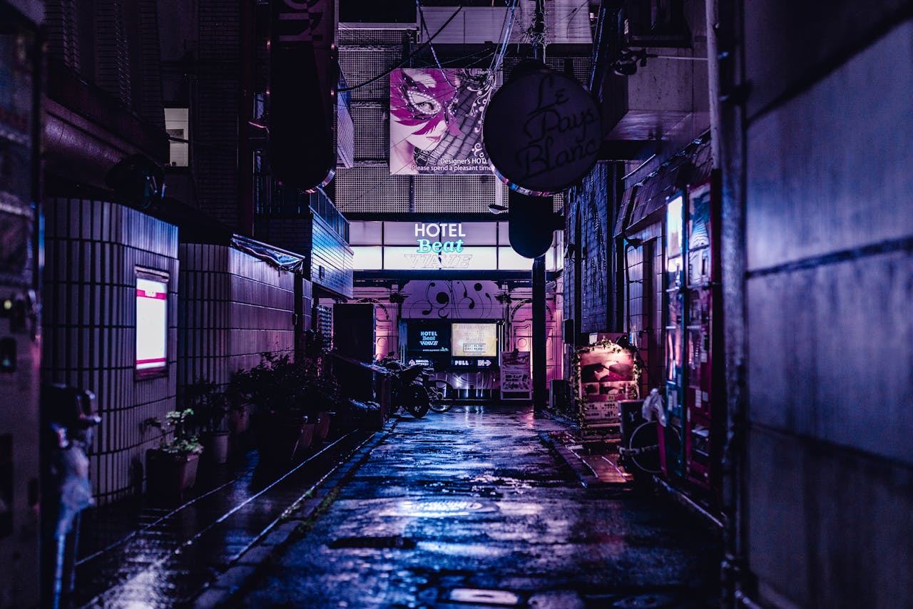 team-05 A vivid night scene capturing a wet alley in Tokyo with neon lights and urban architecture.