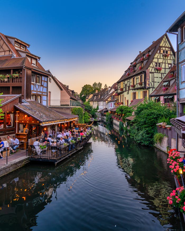 Crafting Captivating Headlines: Your awesome post title goes here Scenic view of a picturesque canal with half-timbered houses in Colmar during sunset.